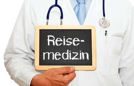 Arzt mit dem Schild Reisemedizin
