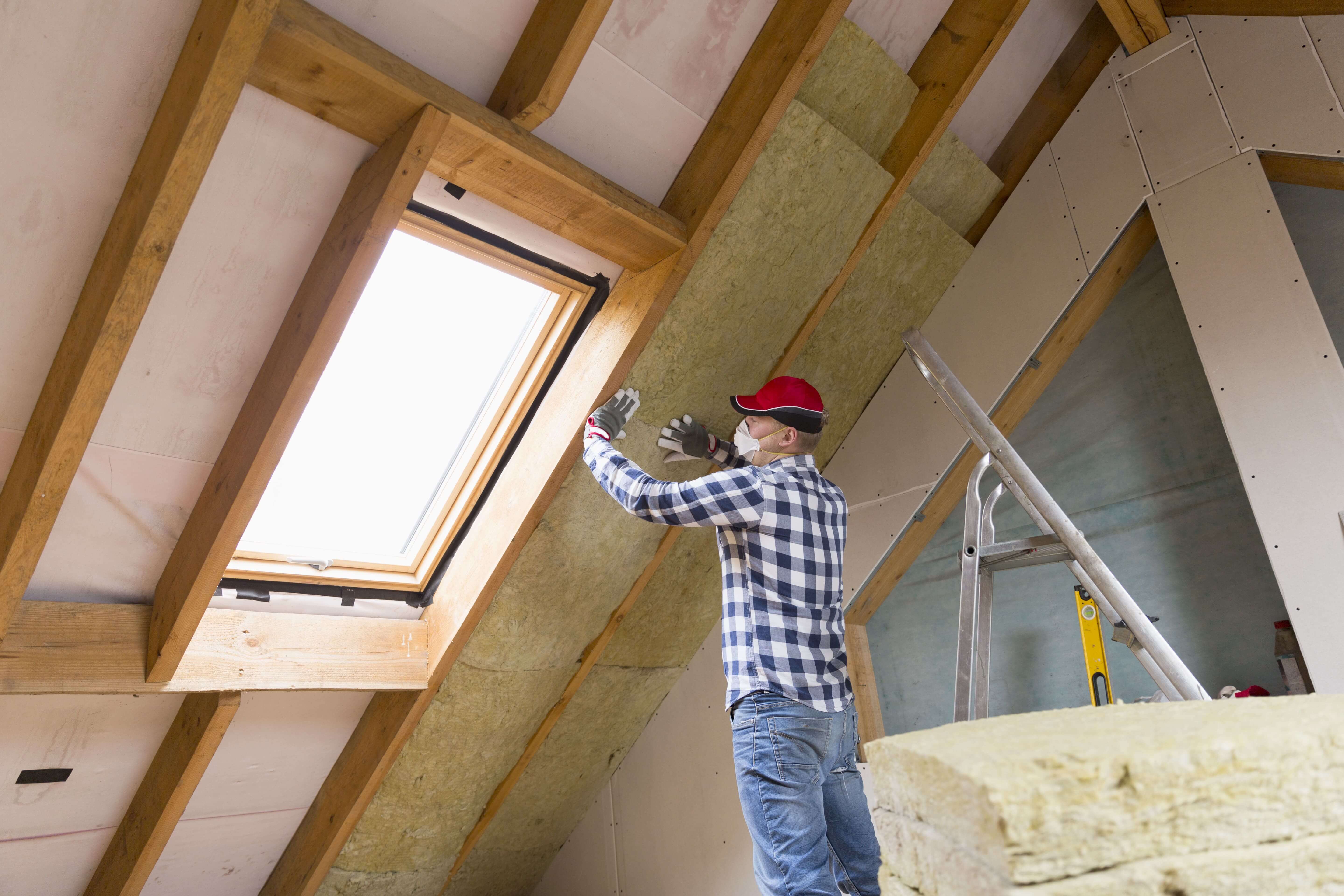 Handwerker dämmt Dach von innen