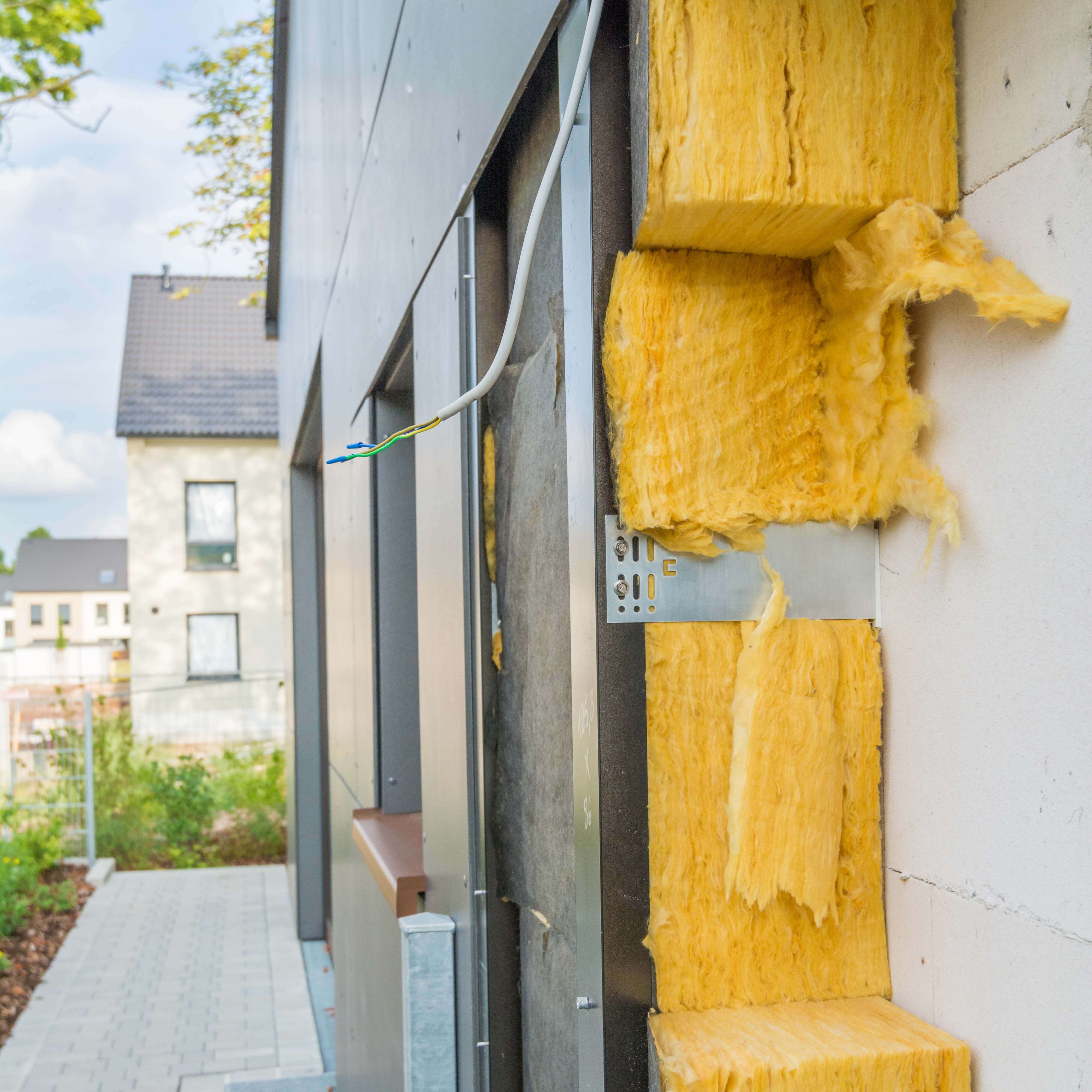 Eine hinterlüftete Fassade bestehend aus Verkleidung und Dämmstoff vor der eigentlichen Fassade