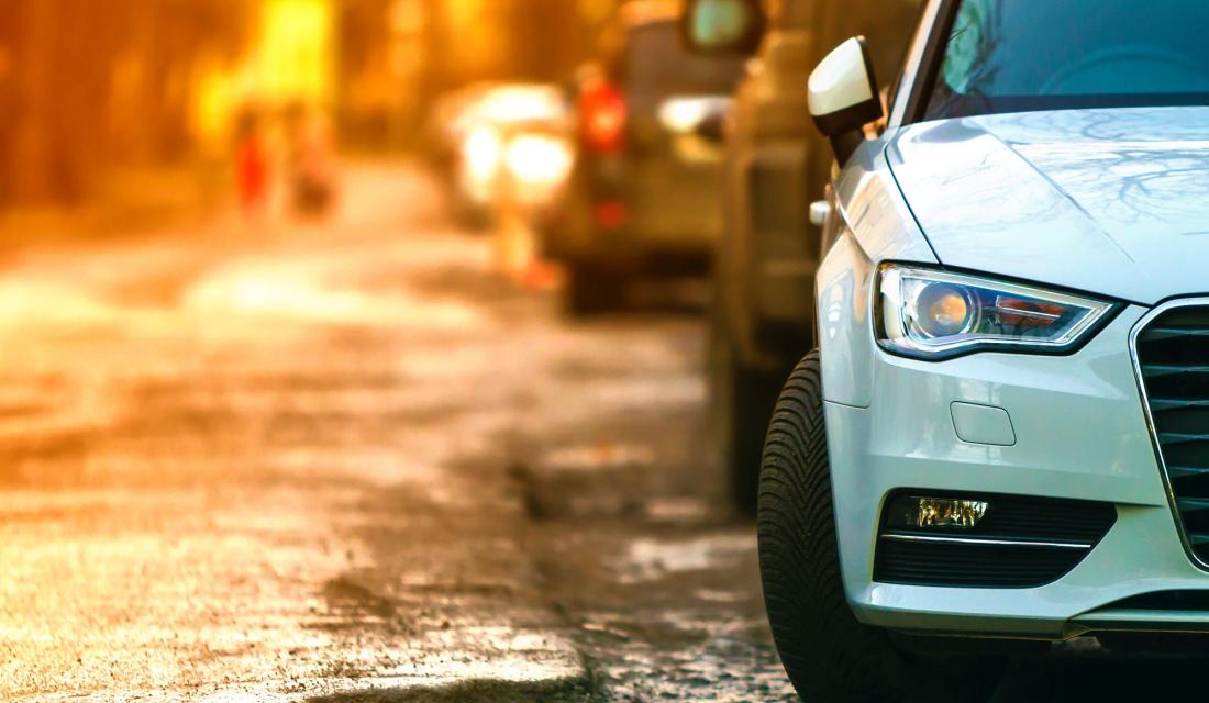 Foto eines an einer Straße geparkten Autos von vorne im Anschnitt