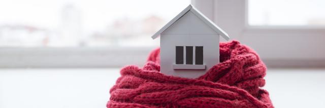 Ein Haus wird mit einem Schal gewärmt