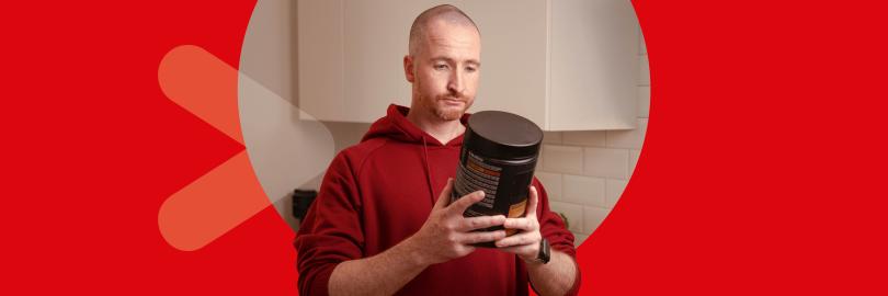 Mann hält Proteinpulver in der Hand