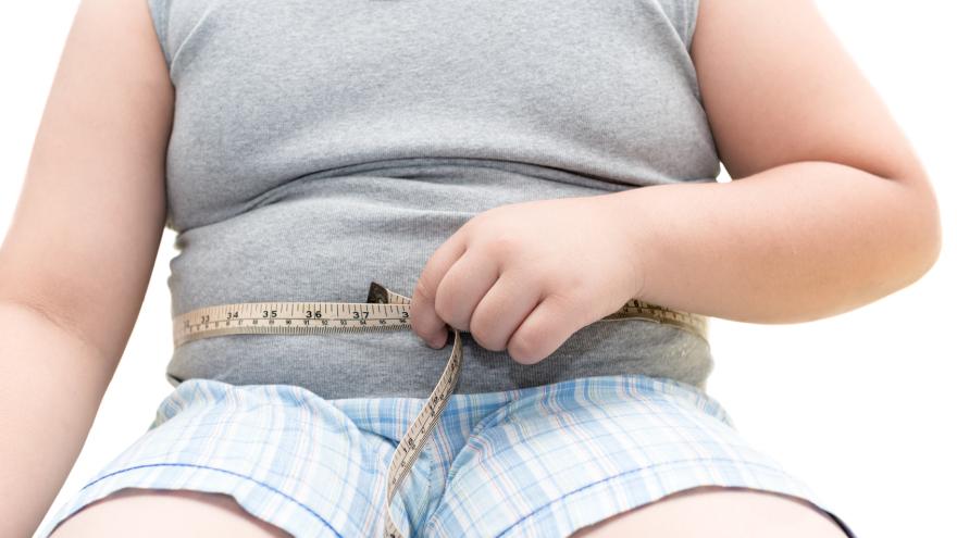 Bauch eines übergewichtigen Jungen mit Maßband.