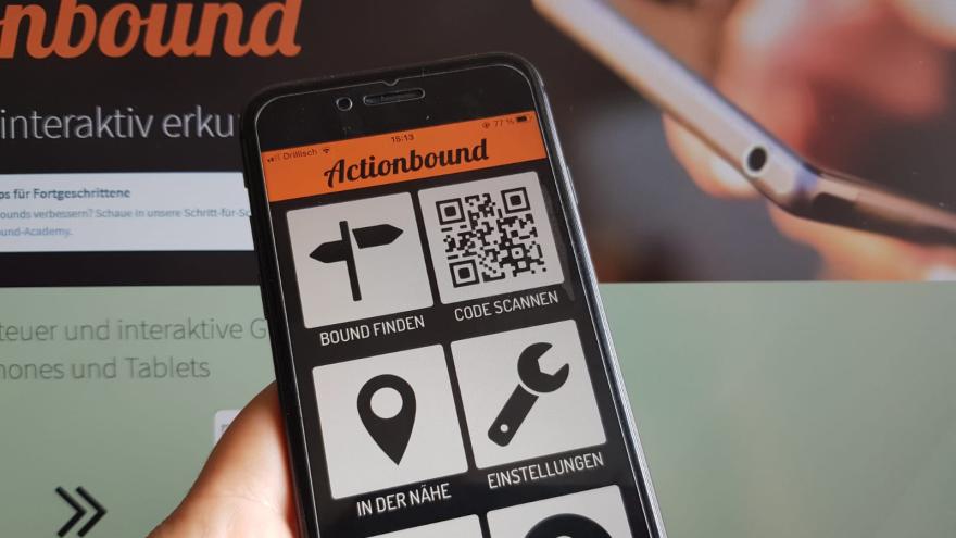 Handy vor Bildschirm mit App Actionbound