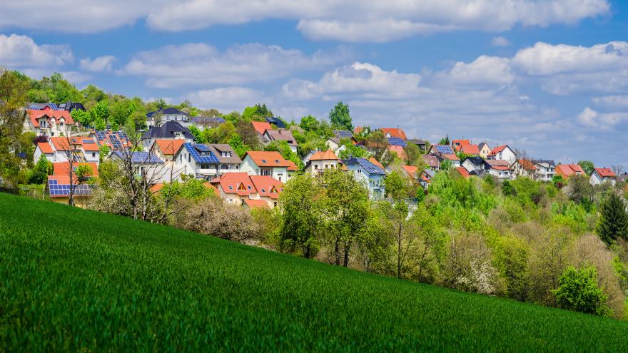 Wohngebiet mit Solardächern vor grüner Wiese