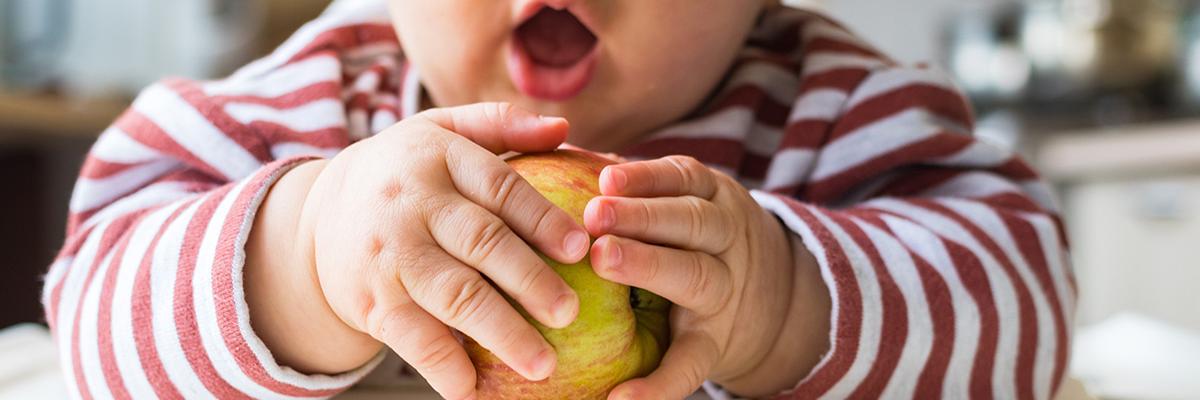 Kleinkind umklammert Apfel