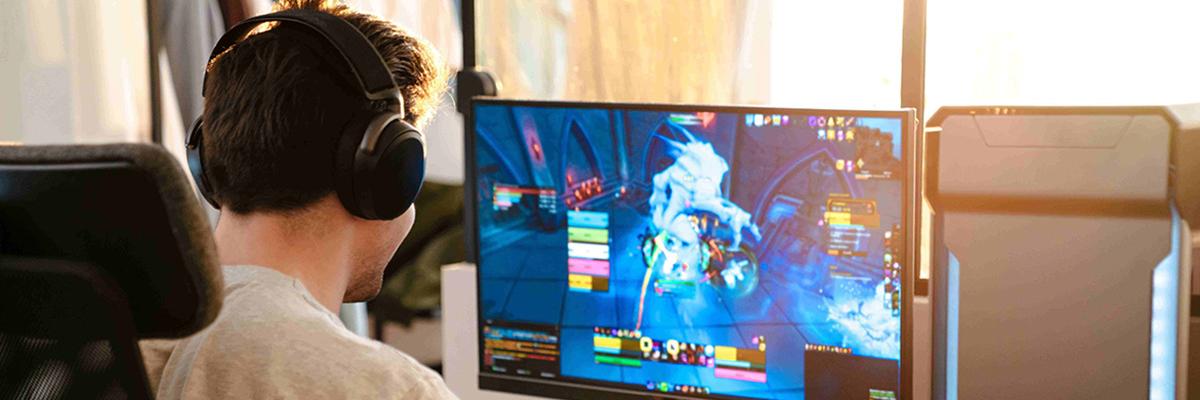 Ein Junge spiel ein Online-Game und hat Headphones auf.