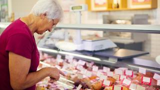 Eine Dame an der Fleischtheke im Supermarkt