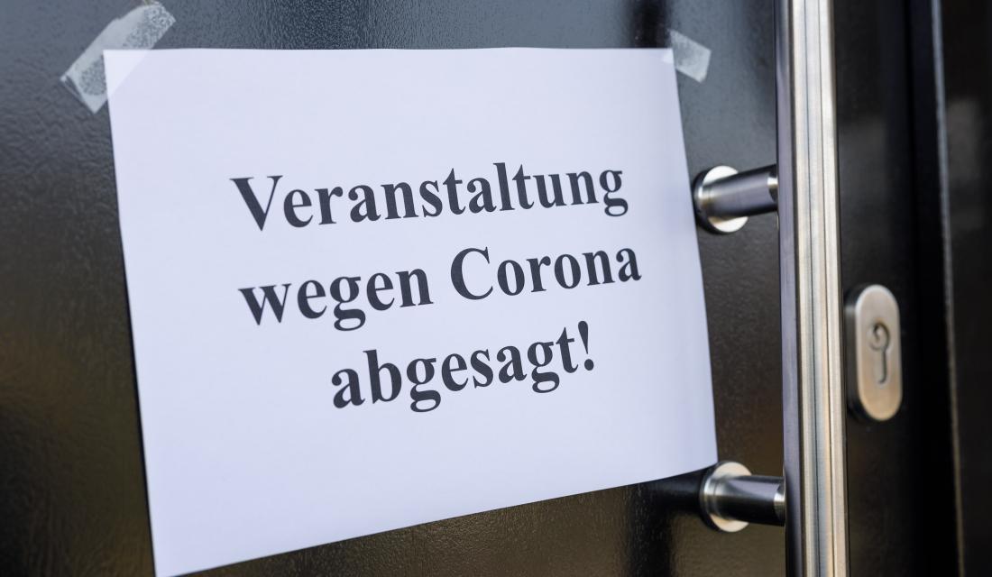 Ein Zettel hängt an einer Scheibe, dass Veranstaltung wegen Corona abgesagt ist.